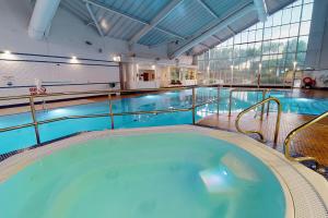 a swimming pool with a large tub in a building at Village Hotel Liverpool in Prescot