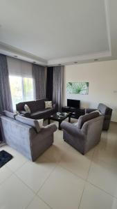 ein Wohnzimmer mit 2 Sofas und einem TV in der Unterkunft Oytam apt in Nikosia