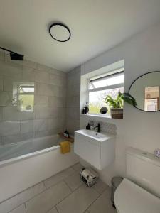 bagno con vasca, lavandino e specchio di Modern, central bungalow with Luxury Hot tub a Bournemouth