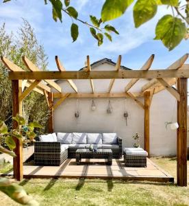 a pergola with a couch in a backyard at Modern, central bungalow with Luxury Hot tub in Bournemouth