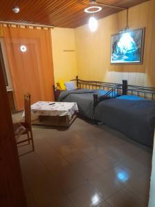 a room with two beds and a table and a tv at Monteurunterkunft Haus Barbara Pirmasens in Pirmasens