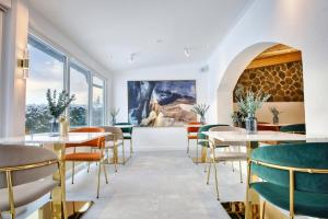 ein Restaurant mit Tischen und Stühlen und einem Gemälde an der Wand in der Unterkunft Das Kronberg Hotel - Adults Only - inkl Soft- und Heißgetränkeflat in Bodenmais