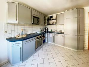 uma cozinha com electrodomésticos de aço inoxidável e azulejos brancos em Appartement DOM I - Erfurt Domplatz em Erfurt