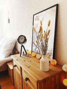 une table avec une horloge et un vase avec des fleurs. dans l'établissement Appartement DOM I - Erfurt Domplatz, à Erfurt