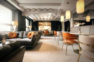 uma sala de estar com um sofá e cadeiras e um bar em Das Kronberg - Adults Only Hotel em Bodenmais