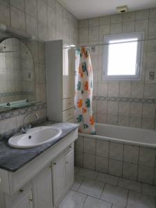 baño con lavabo, bañera y ventana en Pavillon 6 personnes en Corgirnon