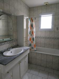 a bathroom with a sink and a tub and a window at Pavillon 6 personnes in Corgirnon