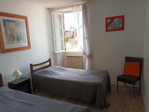 1 dormitorio con 2 camas, ventana y silla en Gîte d'étape Zuharpeta Randonneur Pèlerin, en Saint-Jean-Pied-de-Port