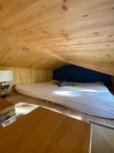 Cama en habitación con techo de madera en Tiny House Möhne im PIER9 Tiny House Hotel, en Hamm