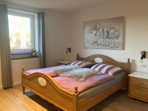 a bedroom with a wooden bed with a blanket on it at Ferienwohnung Am Holzfeld in Schneverdingen