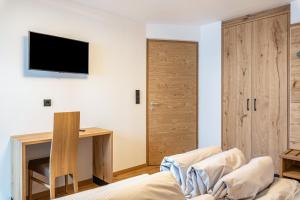 a living room with a couch and a tv on the wall at Planerhof Apartment Lilie in Funes