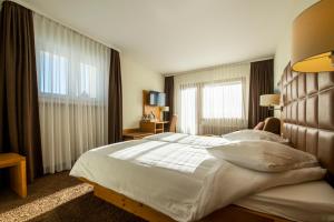 una persona sdraiata su un letto in una camera d'albergo di Hotel Olympic - Montana Center a Crans-Montana