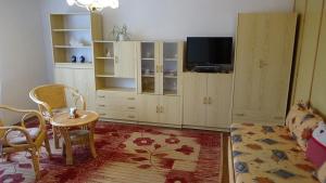 ein Wohnzimmer mit einem TV, einem Tisch und Stühlen in der Unterkunft Apartmán 6 km od centra Banskej Bystrice in Banská Bystrica