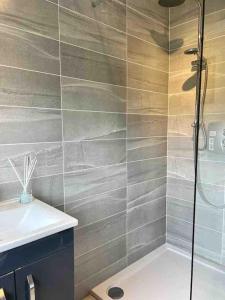 a bathroom with a shower and a sink at Donegal Beach Cottage with Sea Views, sleeps six in Lettermacaward
