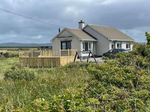 Lettermacaward的住宿－Donegal Beach Cottage with Sea Views, sleeps six，田间中的房子