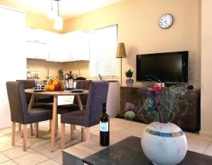 a living room with a table and a tv at Odyseia Apts ΙI at the Center of the City & Old Town in Chania Town