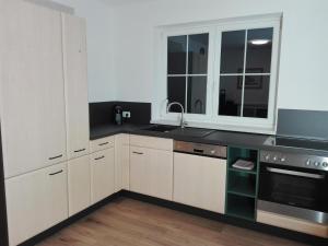 cocina con armarios blancos y encimera negra en Appartement Juffinger, en Thiersee