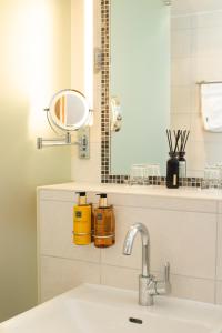 a bathroom with a sink and a mirror at Hotel Olympic - Montana Center in Crans-Montana