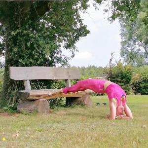 a child doing a handstand next to a bench at Darssblick in Fuhlendorf