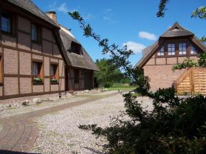 an old house with a thatched roof and a driveway at Boddenzauber in Fuhlendorf