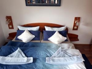 a blue and white bed with blue and white pillows at Boddenzauber in Fuhlendorf