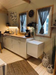 una cocina con armarios blancos y un reloj en la pared en Tiny House Werse im PIER9 Tiny House Hotel en Hamm