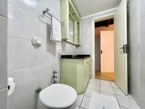 y baño con aseo blanco y lavamanos. en Apartamento San Pietro CENTRO 3 dorm by Achei Temporada, en Gramado