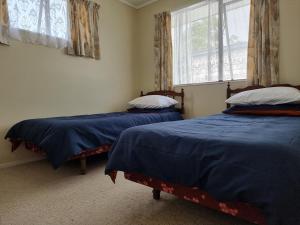 - une chambre avec 2 lits et une fenêtre dans l'établissement Hosts on the Coast Mum and Dads Place, à Whitianga