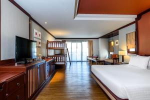 a bedroom with a bed and a flat screen tv at Beyond Samui in Chaweng