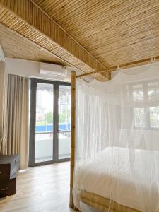 um quarto com uma cama e um tecto em madeira em Song Anh Indochina Studios Pasteur em Cidade de Ho Chi Minh