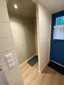 eine ebenerdige Dusche mit blauer Tür in einem Zimmer in der Unterkunft Tiny House Ems im PIER9 Tiny House Hotel in Hamm