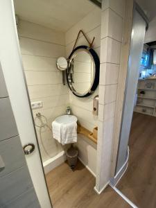 a small bathroom with a mirror and a sink at Tiny House Ems im PIER9 Tiny House Hotel in Hamm