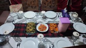a table with plates and bowls of food on it at Cendana Homestay in Sawahlunto