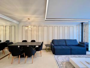 a living room with a blue couch and a table at Apartamento Solar do Ipê Centro 2 dorm by Achei in Canela