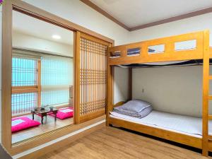 a room with two bunk beds and a table at Cocoa Guesthouse in Seoul