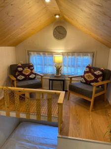 a living room with two chairs and a table at Tiny House Lippe im PIER9 Tiny House Hotel in Hamm +7 photos