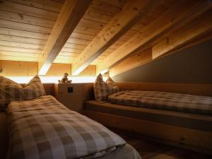 two beds in a room with wooden ceilings at Panorama Hotel & Restaurant in Bettmeralp