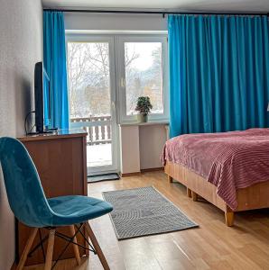 a bedroom with a bed and a desk and a chair at Willa RADosna in Karpacz