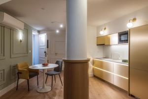 Una cocina con una mesa y dos sillas y una mesa. en The Blossom Collection in Heraklion City Center, Sea View, en Heraclión