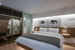 sypialnia z dużym łóżkiem i wyświetlaczem w obiekcie The Blossom Collection in Heraklion City Center w Heraklionie