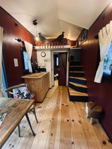 uma sala de estar com pisos em madeira e uma escadaria numa pequena casa em Tiny House Bigge im PIER9 Tiny House Hotel em Hamm