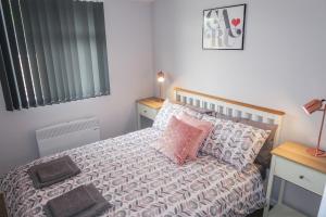 a bedroom with a bed with pillows on it at Riverside Chalet in heart of Lampeter, West Wales in Lampeter