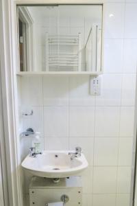 ein weißes Badezimmer mit einem Waschbecken und einem Spiegel in der Unterkunft Riverside Chalet in heart of Lampeter, West Wales in Lampeter