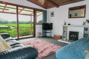 ein Wohnzimmer mit einem Sofa und einem Kamin in der Unterkunft Riverside Chalet in heart of Lampeter, West Wales in Lampeter