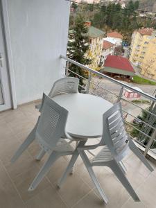 d'une table blanche et de deux chaises sur un balcon. dans l'établissement CAN APART KAPLICA OTEL, à Termal