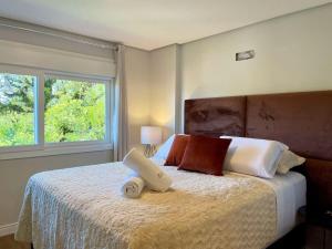 um quarto com uma cama grande e 2 almofadas em Apartamentos Delle Alpi by Achei Gramado em Canela