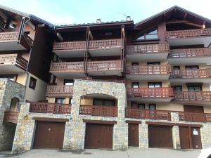 an apartment building with brown doors and balconies at Appartement 1 chambre, 4 personnes in Champagny-en-Vanoise
