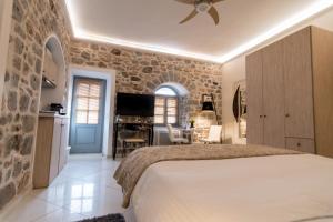 um quarto com uma cama e uma parede de pedra em Paradiso em Hydra