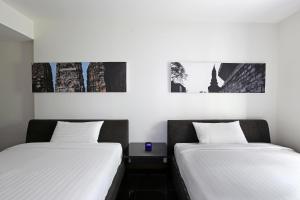 twee bedden naast elkaar in een kamer bij S33 Compact Sukhumvit Hotel in Bangkok