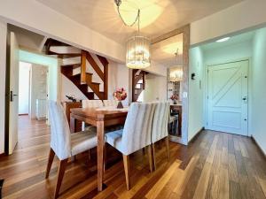 comedor con mesa de madera y sillas en Apartamentos Solar da Colina CENTRO by Achei Gramado, en Canela